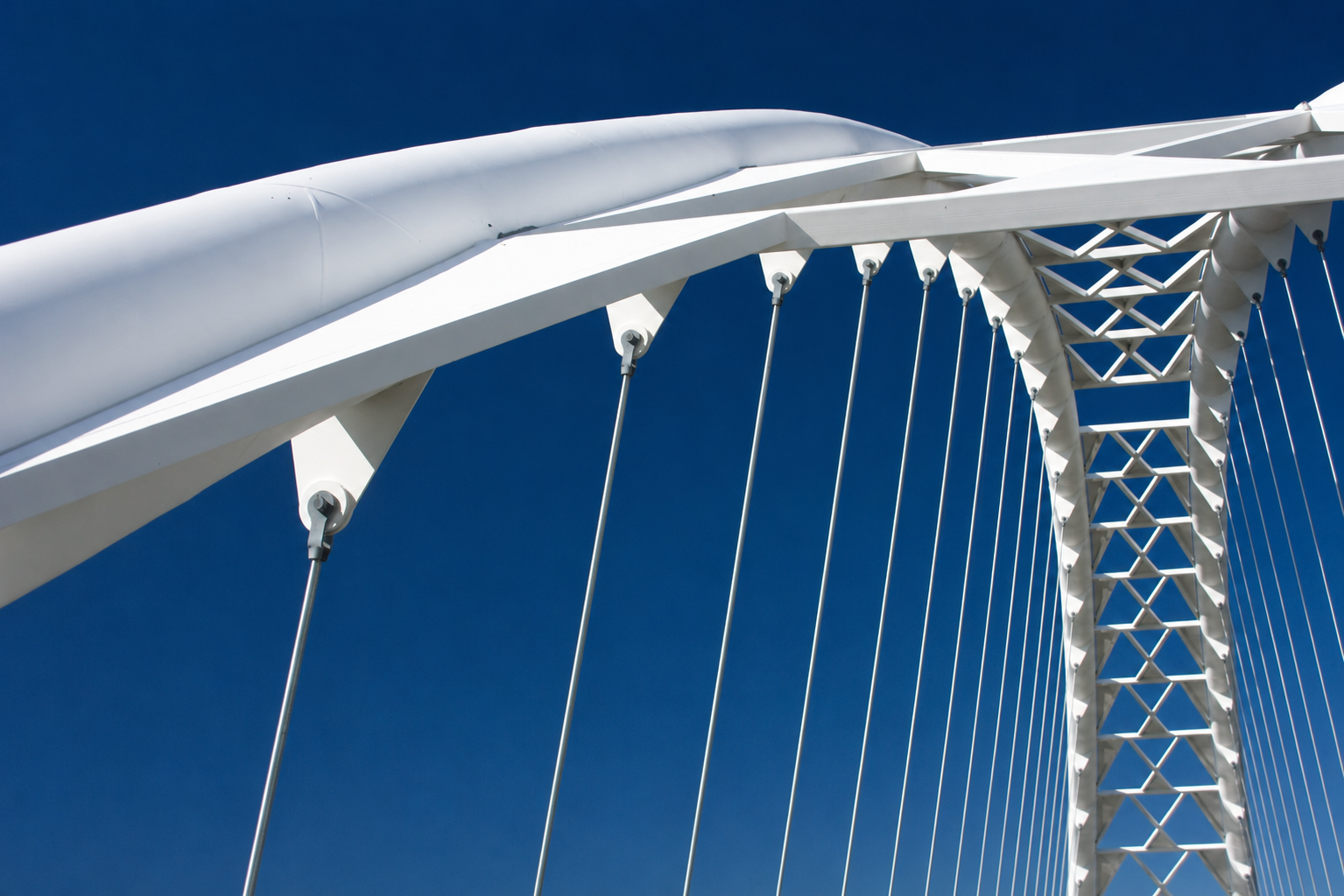 White structural steel bridge against blue sky